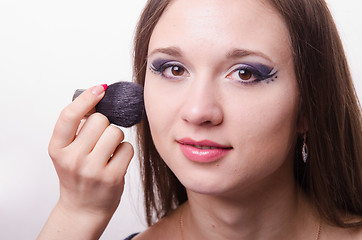 Image showing Makeup artist brush powder on face causes model
