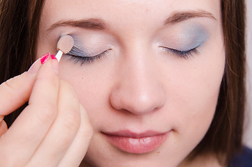 Image showing Makeup artist applies eye shadow model