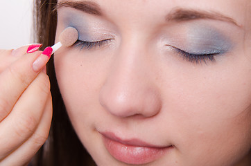 Image showing Makeup artist is shaded eyelids model with makeup