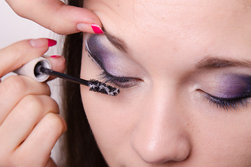 Image showing Makeup artist applies foundation under mascara on eyelashes