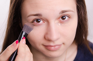 Image showing Makeup artist brush smears concealer on the eyelids model