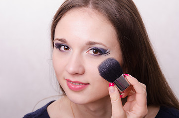 Image showing Makeup artist brush powders face of a beautiful girl