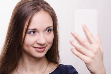 Image showing Beautiful young girl looking in the mirror
