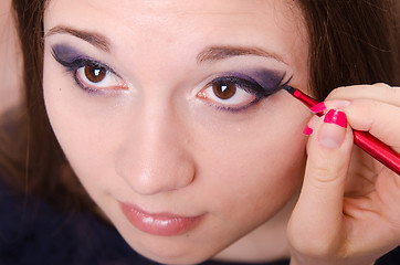 Image showing Bright makeup. Makeup artist draws arrows