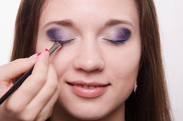 Image showing Makeup artist embellish eyelashes of a beautiful girl