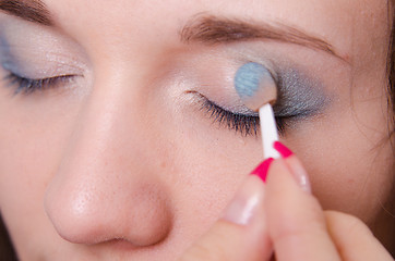 Image showing Makeup artist is shaded eyelids as makeup