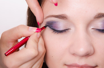 Image showing Bright makeup. Makeup artist begins to draw arrows