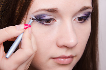 Image showing Sad girl makeup artist draws arrows