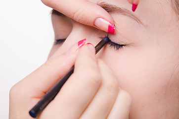 Image showing Makeup artist brings pencil eyelashes girl