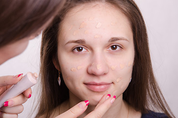 Image showing Makeup artist gets his hands on the face concealer