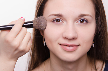 Image showing Makeup artist applies powder on cheeks of a pretty girl