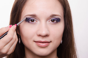 Image showing Makeup artist paints a model ever