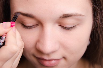 Image showing Makeup artist brush eyebrows brings young girl