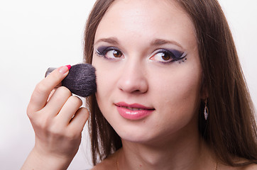 Image showing Makeup artist applies powder on face of beautiful model