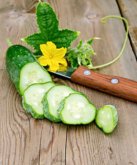 Image showing Cucumber sliced with flower and knife on board