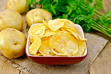 Image showing Chips in bowl with potatoes on sacking and board