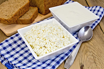 Image showing Curd and sour cream in bowls on board with bread