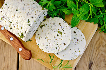 Image showing Cheese homemade with herbs and knife on board