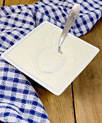 Image showing Sour cream with a spoon on board