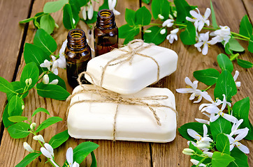 Image showing Soap and oil white with  flowers of honeysuckle on board