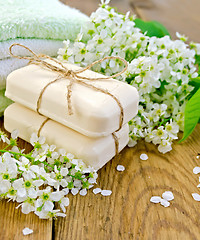 Image showing Soap with towel and bird cherry on board