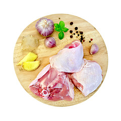 Image showing Chicken thigh cut on round board