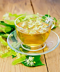 Image showing Herbal tea from linden flowers in glass cup on board