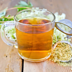 Image showing Herbal tea from meadowsweet dry in mug with strainer