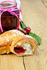 Image showing Bun with cherry jam on board