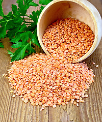 Image showing Lentils red in wooden bowl on board