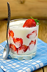 Image showing Yogurt thick with strawberries and spoon on board