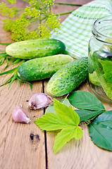 Image showing Cucumbers with jar and garlic on board