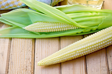 Image showing Corncob with oil and napkin on board