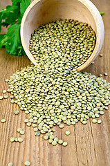 Image showing Lentils green in wooden bowl on board
