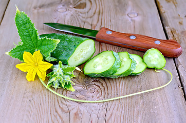 Image showing Cucumber sliced with flower and leaf on board