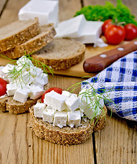 Image showing Bread with feta and tomatoes on board with knife