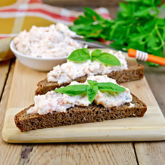 Image showing Sandwich with cream of salmon and knife on board