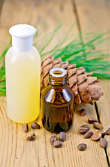 Image showing Oil and lotion with cedar cone on board