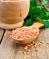 Image showing Lentils red in wooden utensil on board