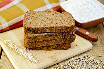 Image showing Rye bread with flour and grain on board