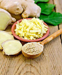 Image showing Ginger powder and grated with root and leaves on board