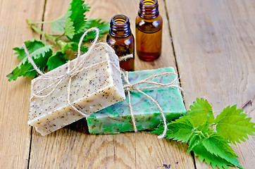 Image showing Soap homemade and oil with nettle on board