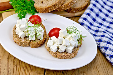 Image showing Bread with feta and tomatoes on plate on board