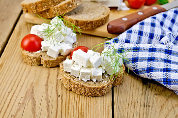 Image showing Bread with feta and tomatoes on board with napkin