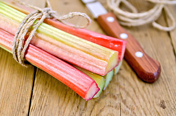 Image showing Rhubarb with twine and knife on board