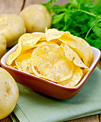 Image showing Chips in bowl with potato on napkin and board