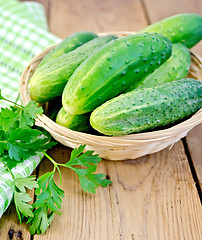 Image showing Cucumbers in wicker basket on board