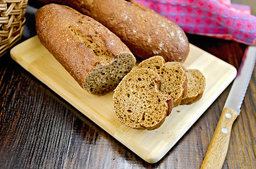 Image showing Rye baguettes with a knife and basket on board