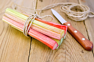 Image showing Rhubarb with coil of rope and knife on board