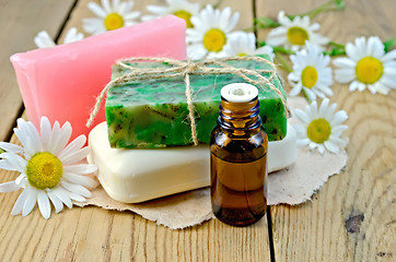 Image showing Oil with soap and camomile on board